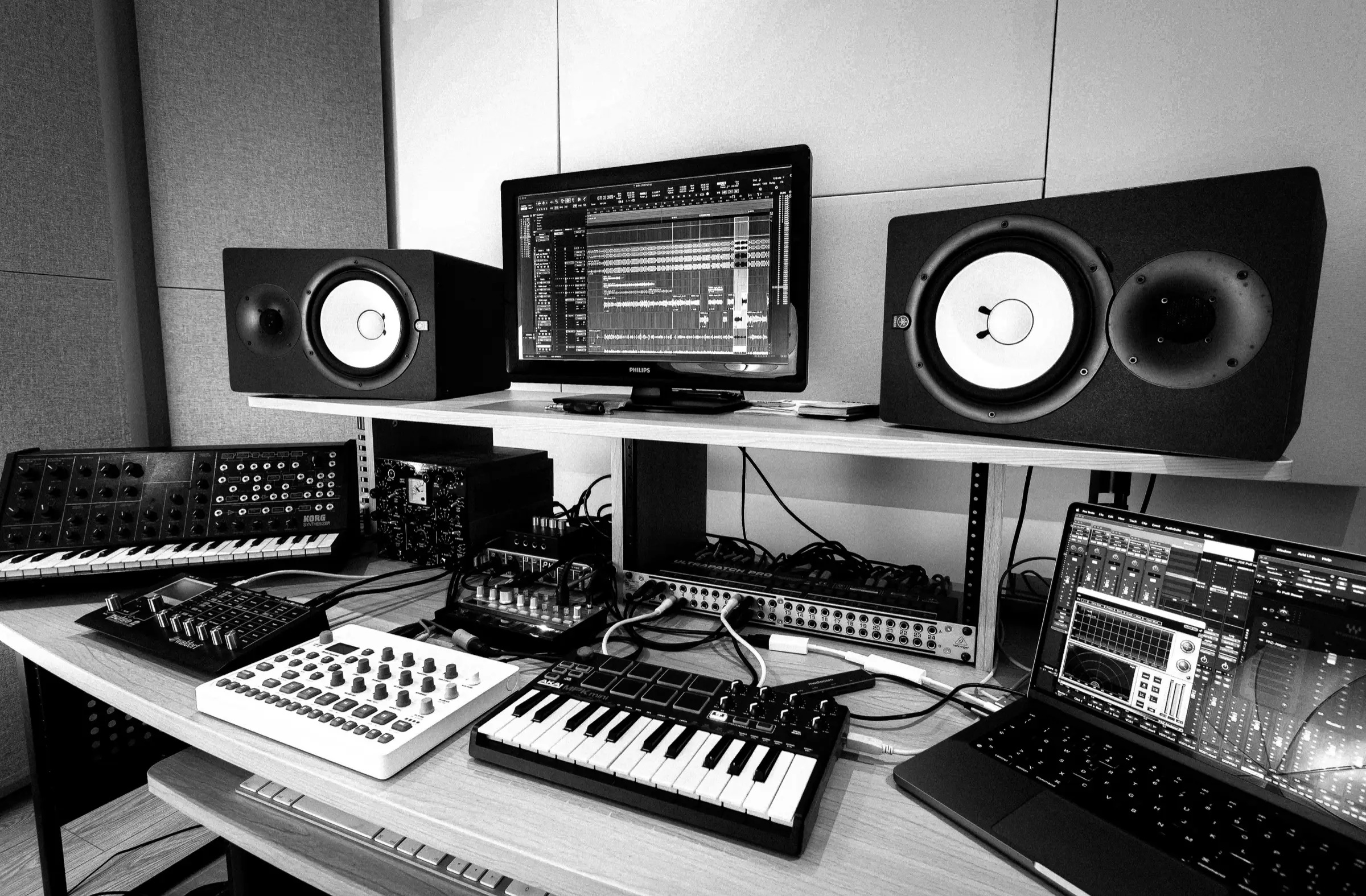 Monitor, synth e controller sulla scrivania di regia